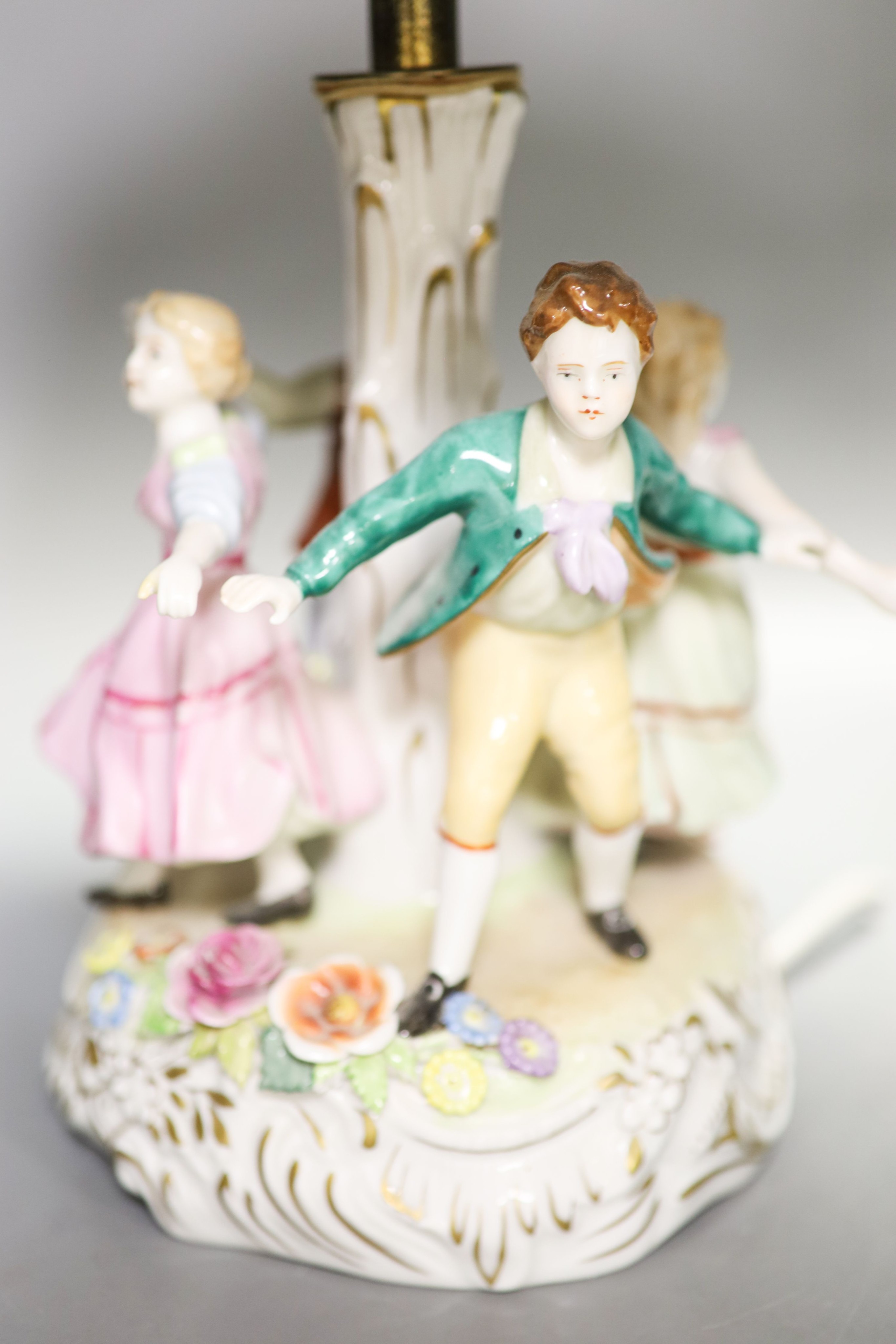 Two pairs of German porcelain table lamps, the stems modelled with figures dancing 56cm